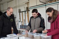 Personen stehen hinter Tisch mit Plastikbehältern